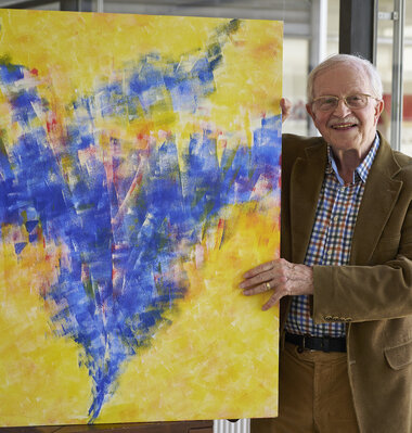 Der Maler mit einem seiner Bilder