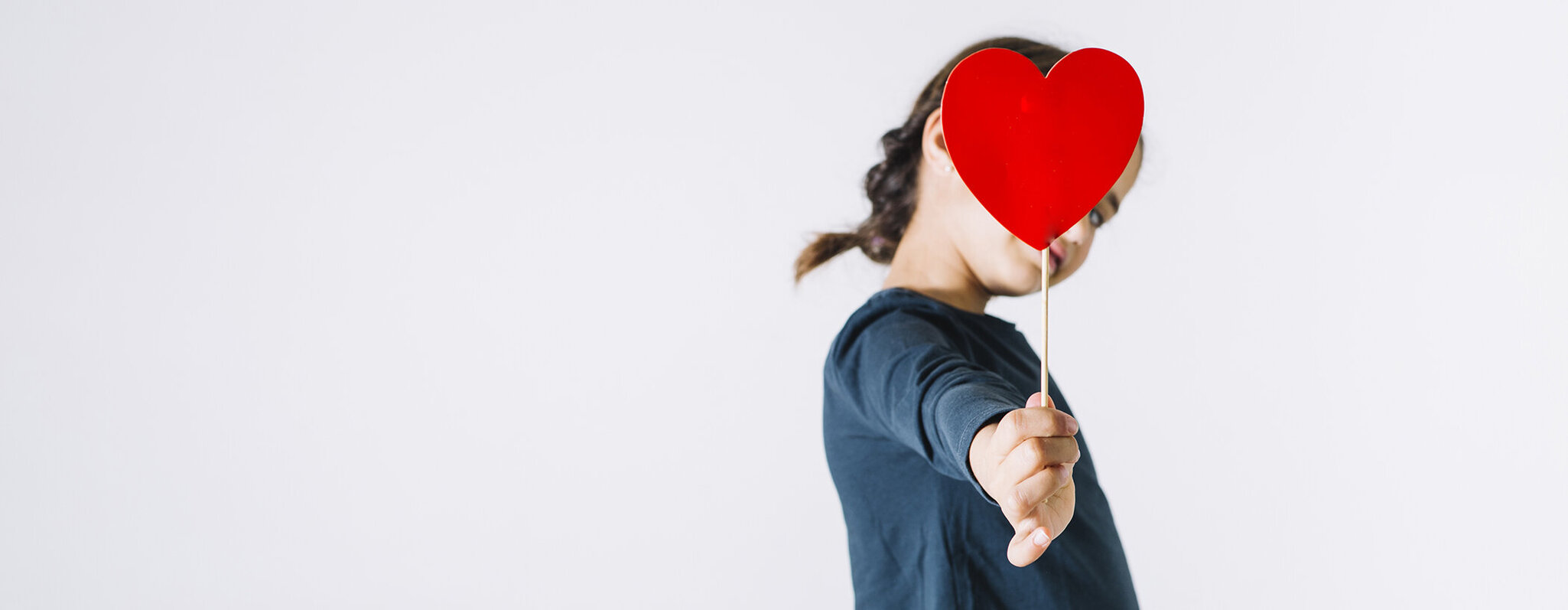 Mädchen, das ein herzförmiges Schild hoch hält